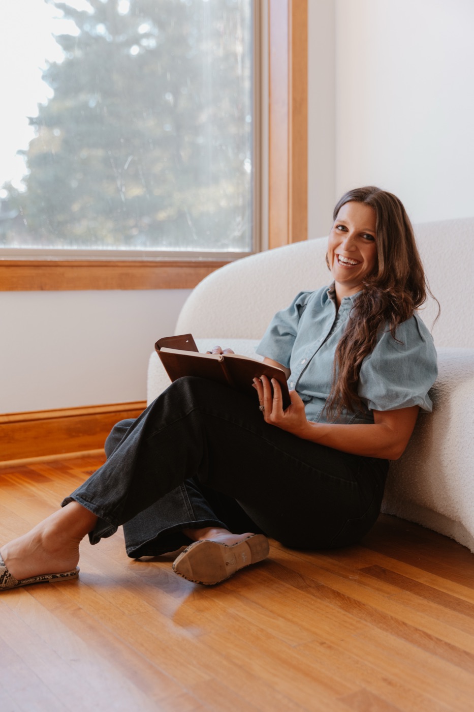 Rachel sitting by a window with a journal
