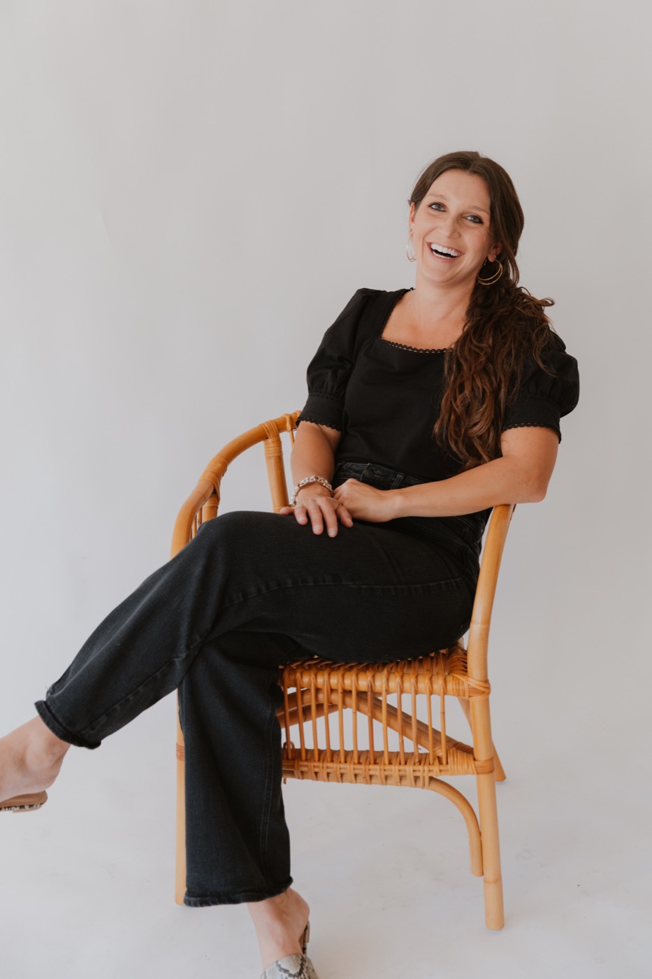 Rachel Lynn Lawrence smiling in a woven chair